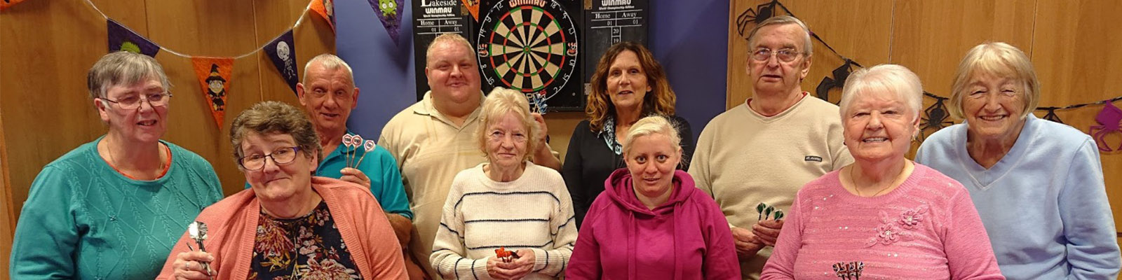 10 residents in front of a dart board