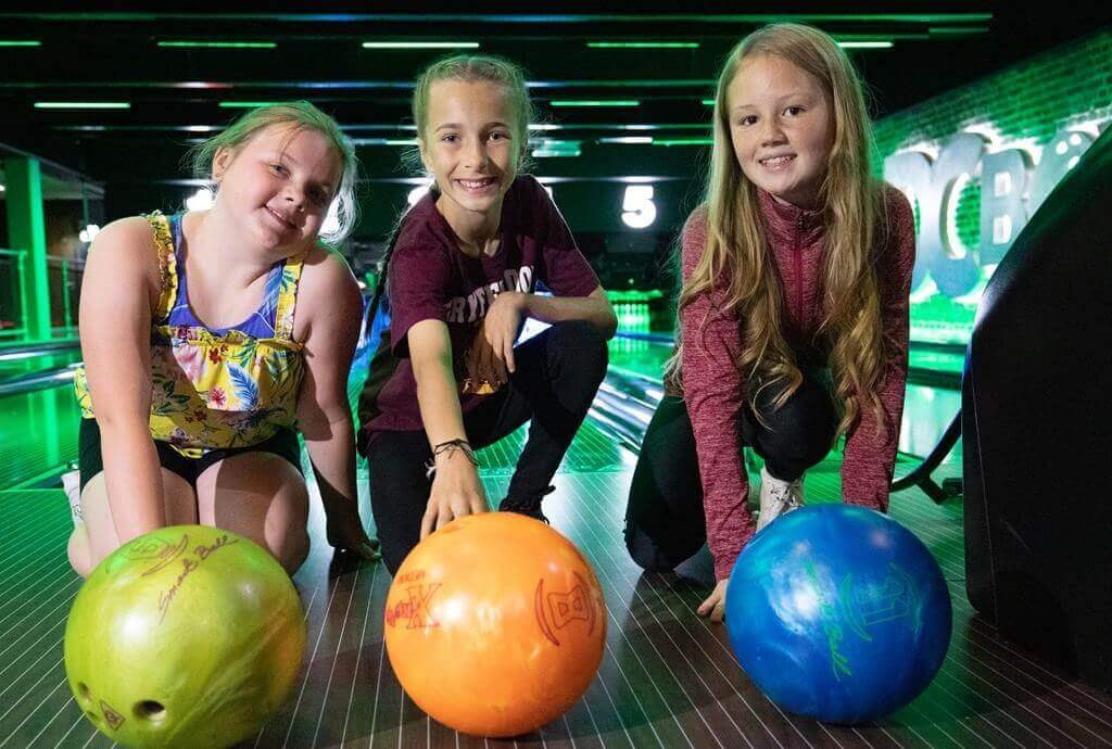 3 girls with bowling balls at DC Bowl