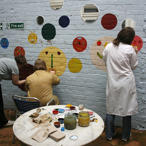artists painting on a wall
