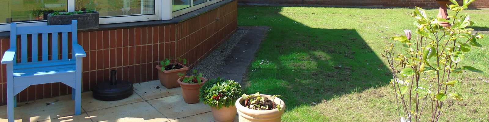 a seating area in the gardens at Ted Fletcher Court