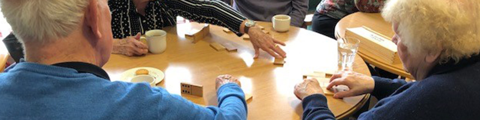 residents playing dominoes over tea and snacks