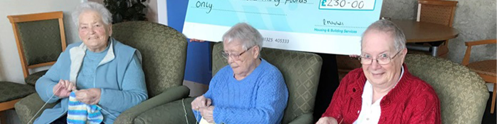 members of the knitting group receiving a cheque