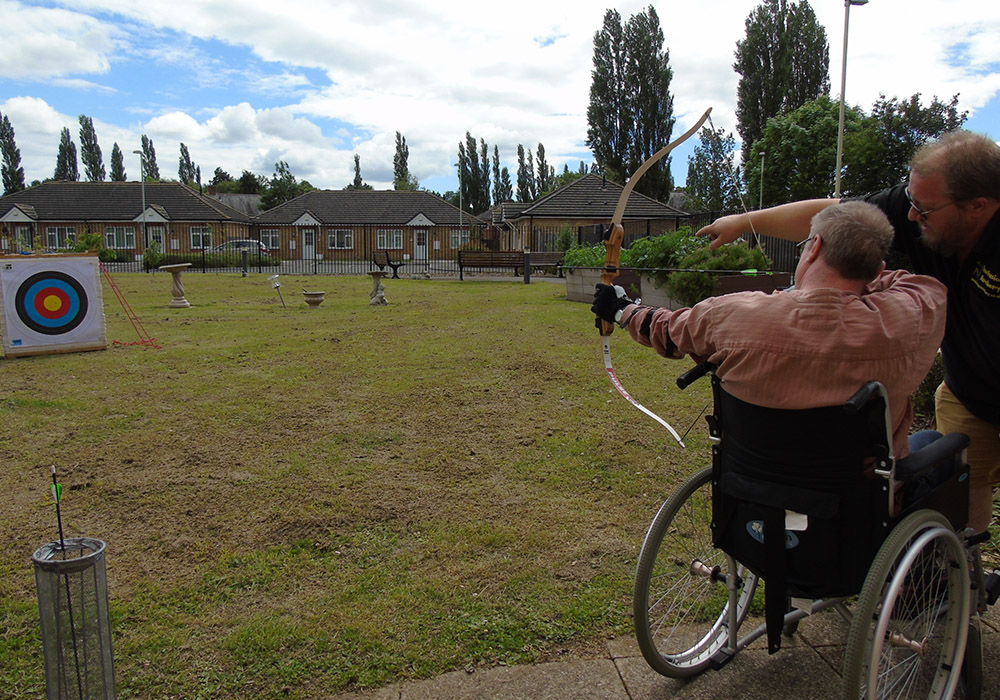 a resident taking part in an archery lesson