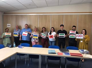 ESOL learners holding up the flags of their home country