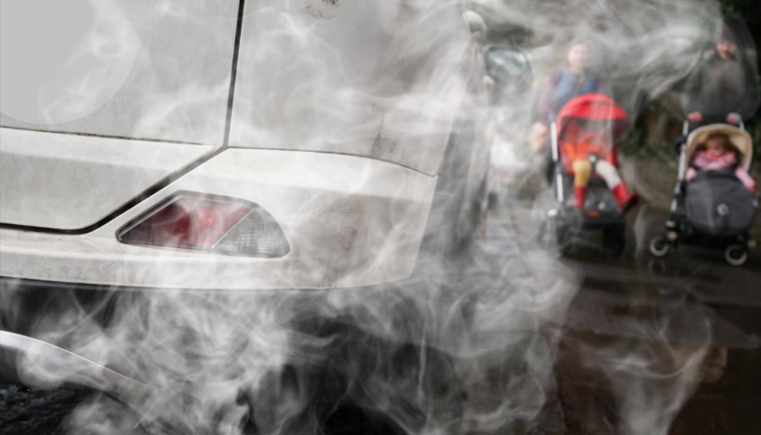 Children in pushchairs passing car with smoke emitting from exhaust