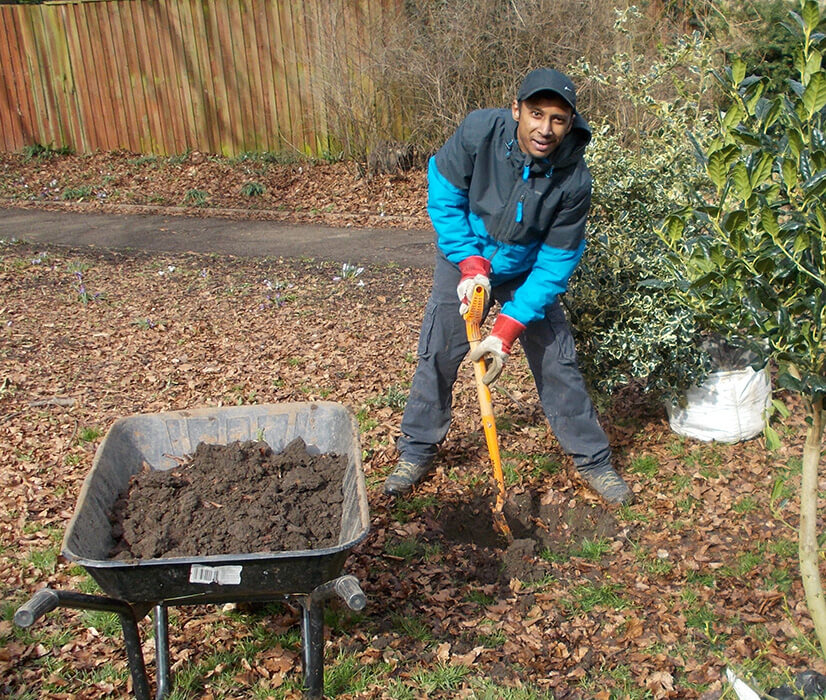 A volunteer fills a wheelbarrow