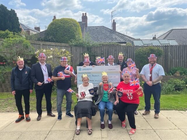 People holding flags and an oversized cheque