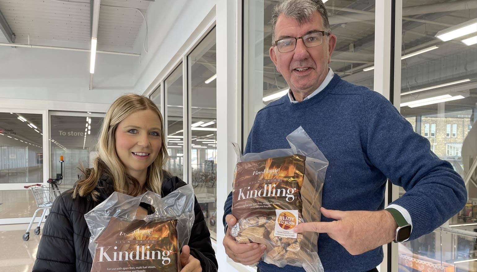 Two people holding bags of kindling