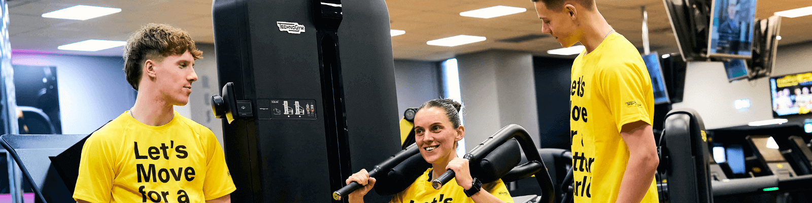 3 people in yellow lets move for a better world t-shirts on gym equipment