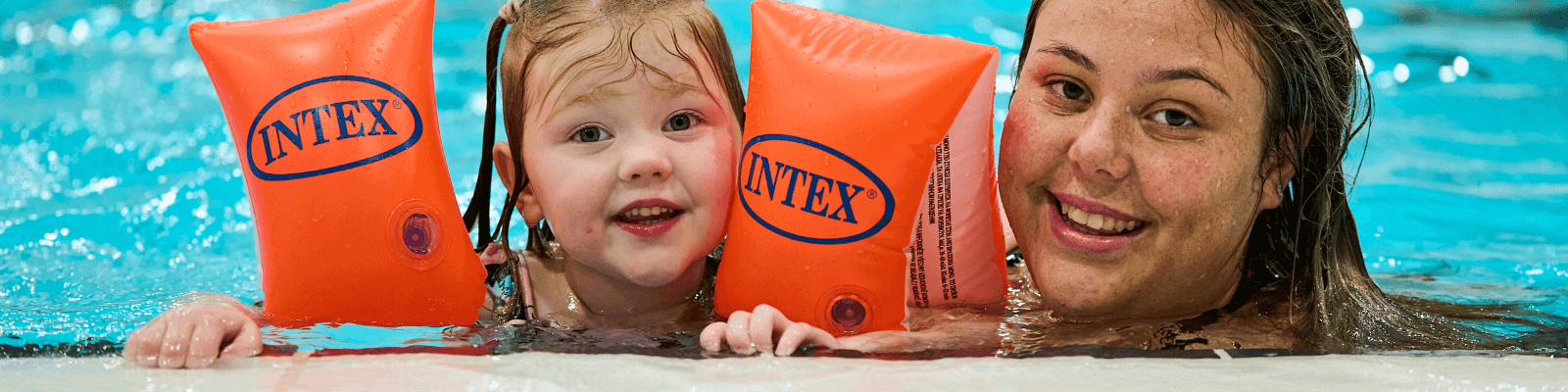 A parent with a child wearing arm bands in the Dolphin Centre pool