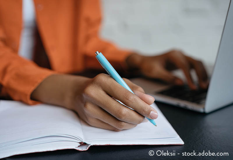 A women takes notes from a laptop