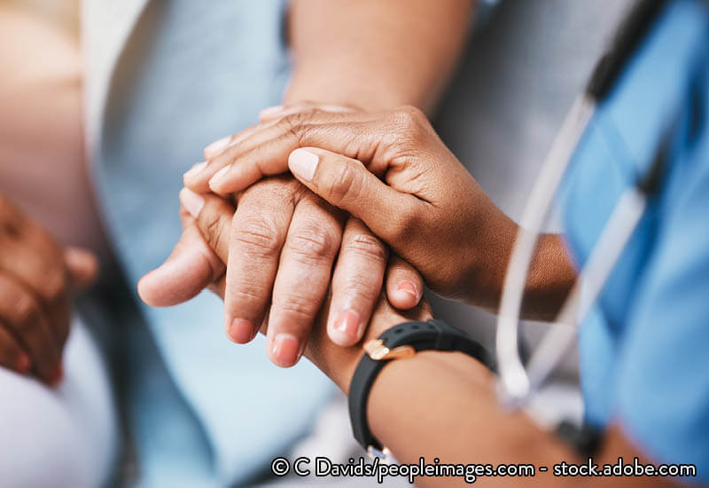 A nurse holding the hand of a patient