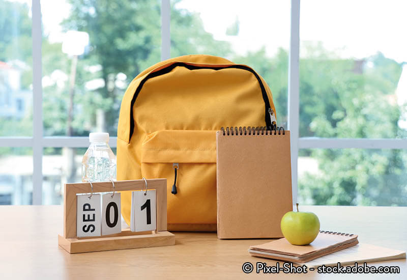 A backpack and a calendar on a table
