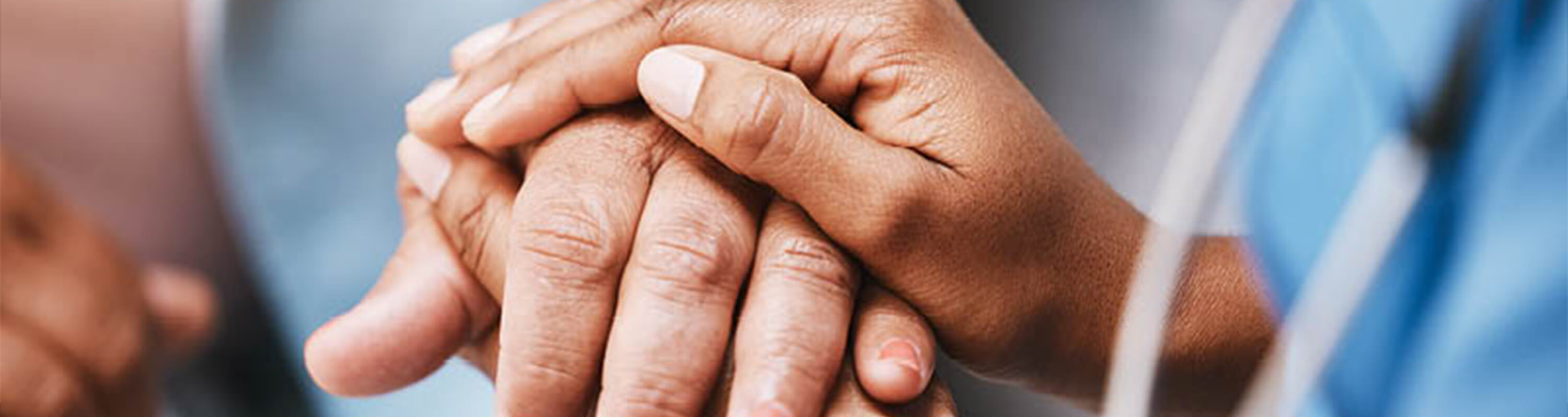 A nurse holds a patients hand