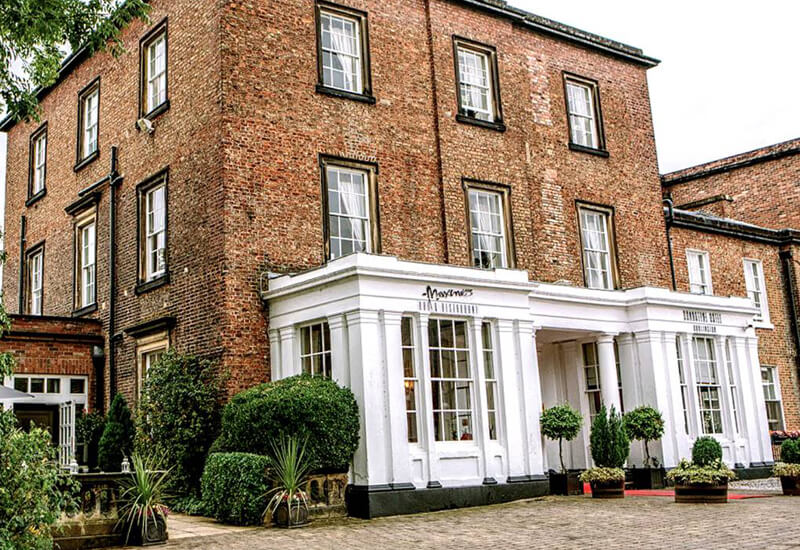 Brick three storey building with ground floor restaurant in white frontage