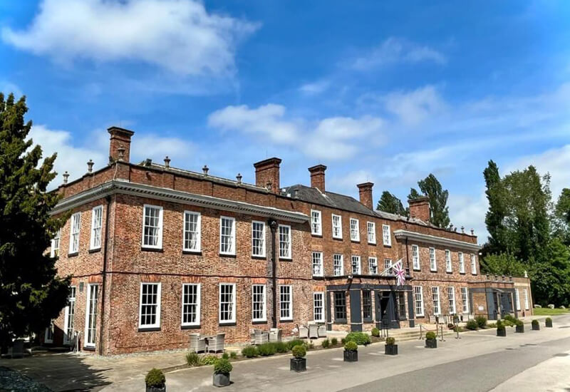Large two and three storey hotel with large drive running past the front