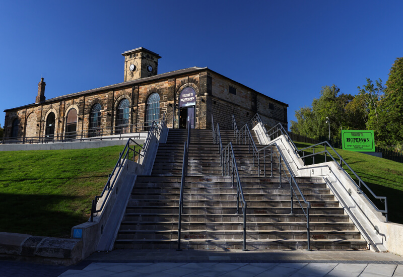 Three external flights of steps leading up to large old brick building
