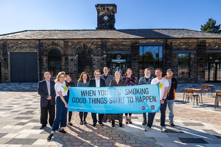 People holding large stop smoking banner