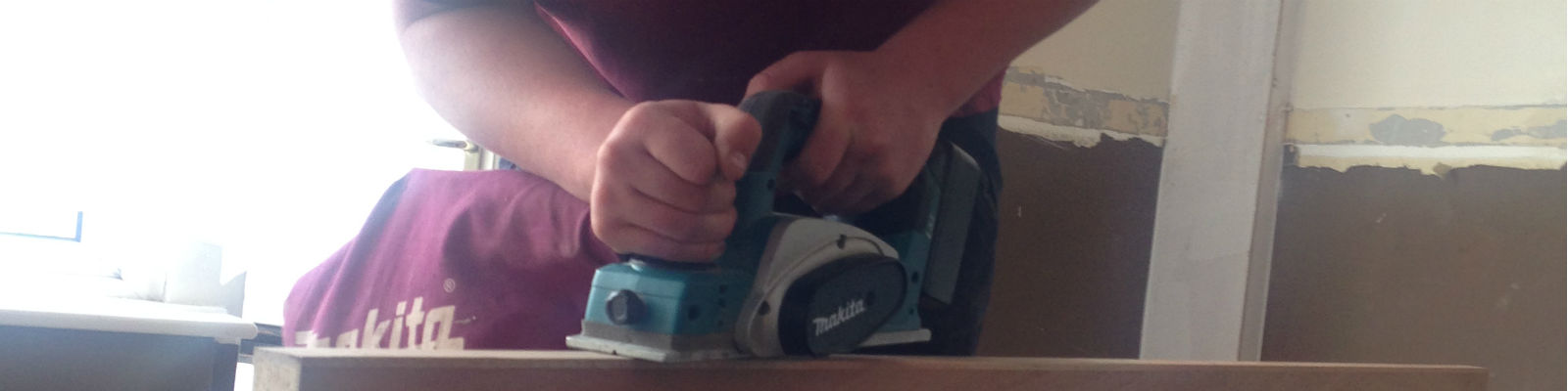 An apprentice using a electric saw